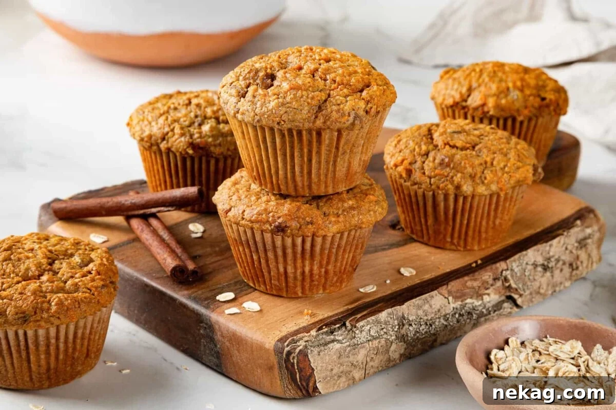 Group of freshly baked healthy carrot muffins displayed on a rustic wooden cutting board, showcasing their golden tops and inviting texture.