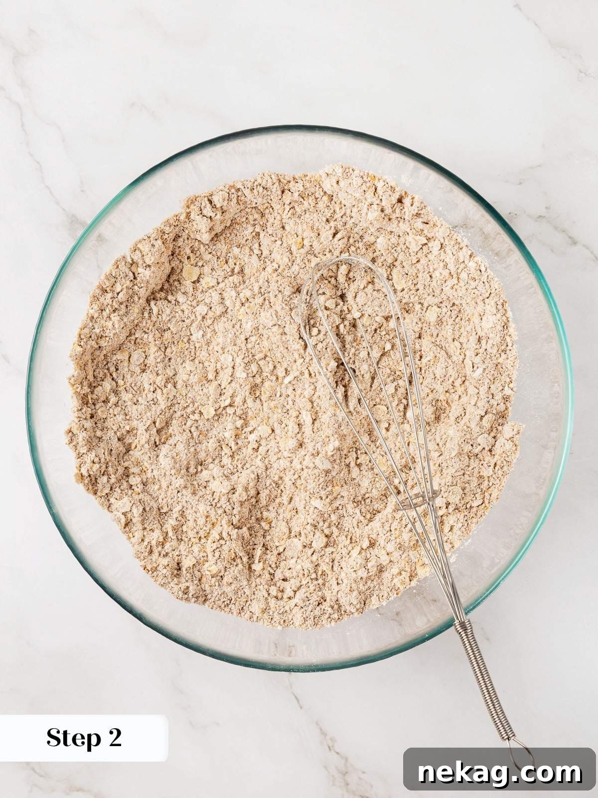 Mixing dry ingredients including whole wheat flour, oats, flax seeds, and various spices for healthy carrot muffins.