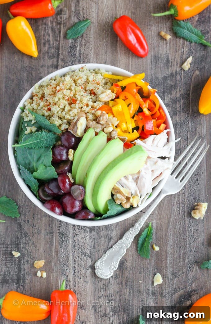 Supercharge Quinoa Kale Bowl 5 A beautiful, close-up overhead shot of the Quinoa Kale Power Bowl, featuring roasted turkey, colorful bell peppers, avocado, feta cheese, and red grapes.