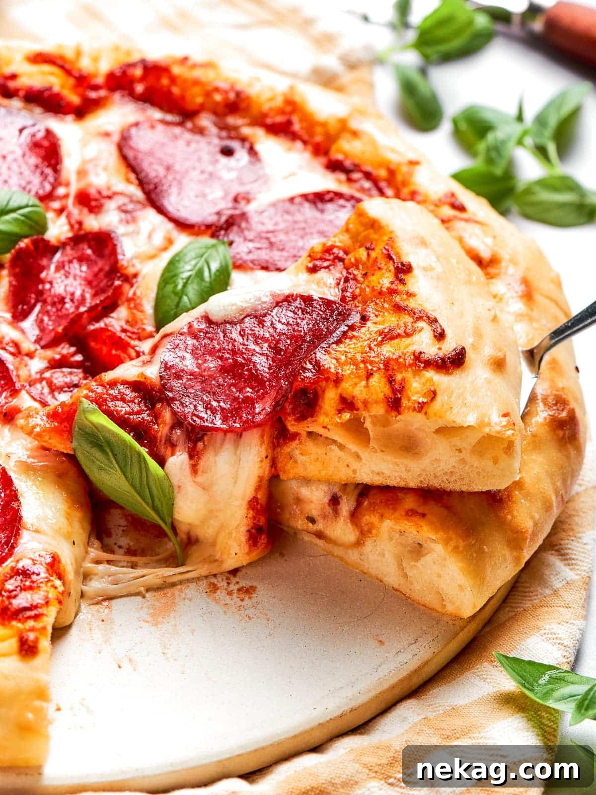 Cheese stretching between two pizza slices mid-pull, showcasing the perfect gooey texture of homemade pepperoni pizza.