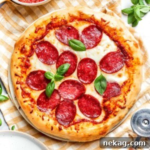 Close-up of golden, crisp crust on baked pepperoni pizza, highlighting the perfect texture.