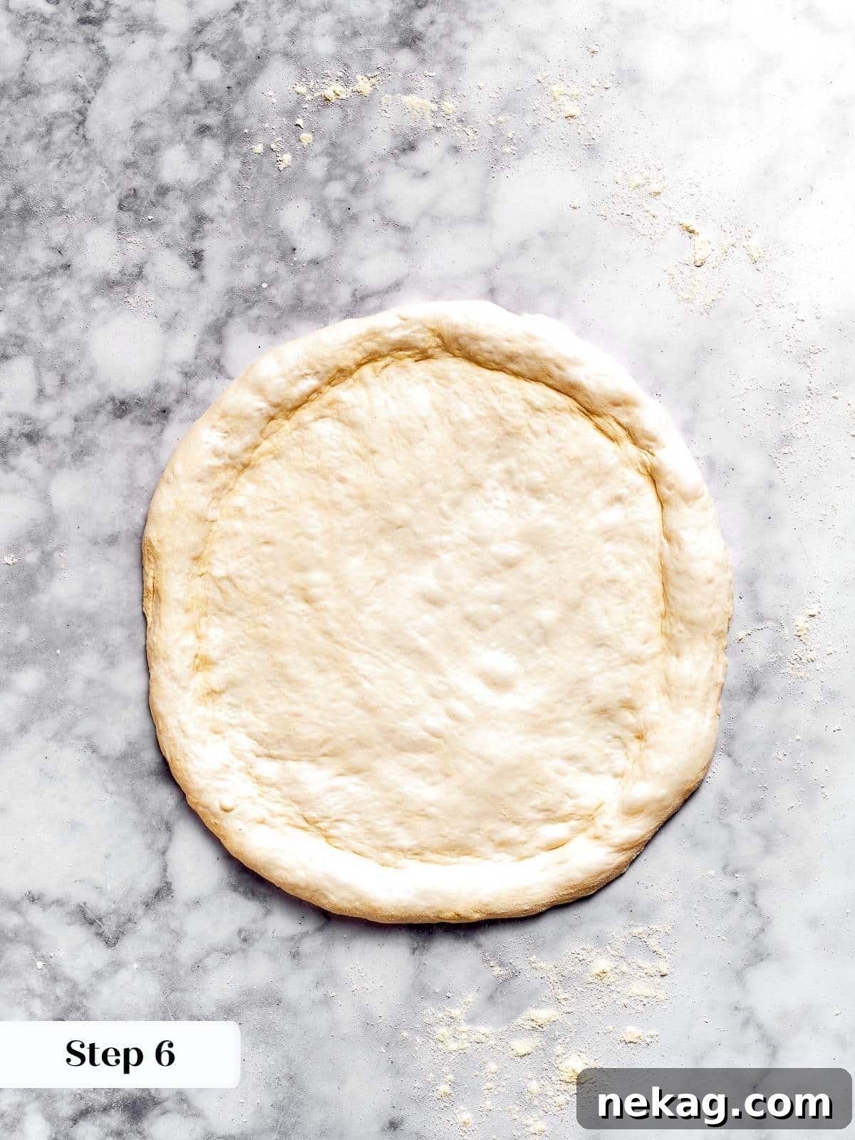 Pizza dough perfectly shaped into a circular base on a floured surface, ready for toppings.
