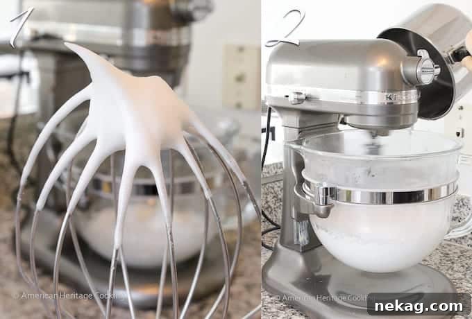 Egg whites whipped to frothy, soft peaks, shown on a silver whisk attachment.