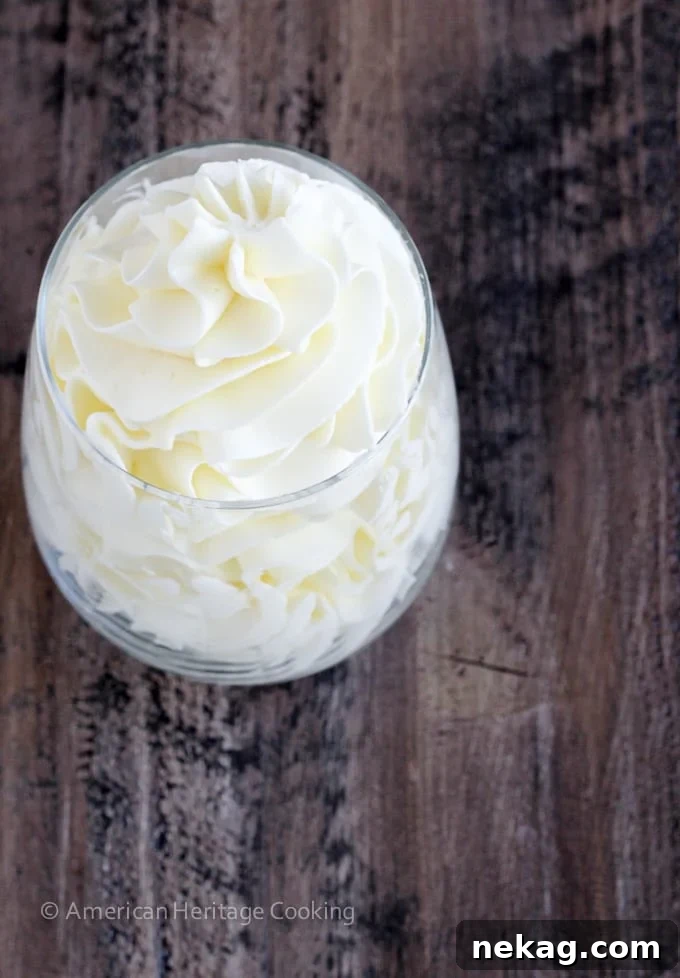 Italian meringue buttercream in a clear glass with graceful swirls, ready to be used.