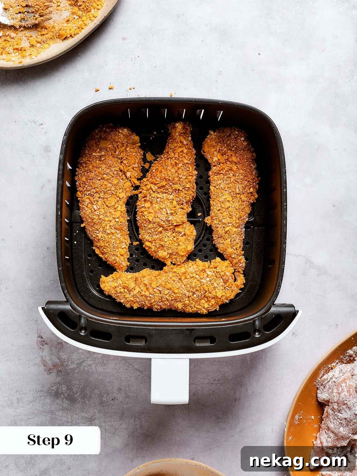 Crispy Air-Fried Chicken Fingers 7 Chicken tenders lined up in air fryer ready to cook to golden crispness.