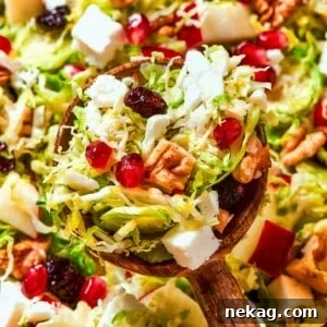 A full spoonful of Brussels sprout salad showing layered textures and bright ingredients.