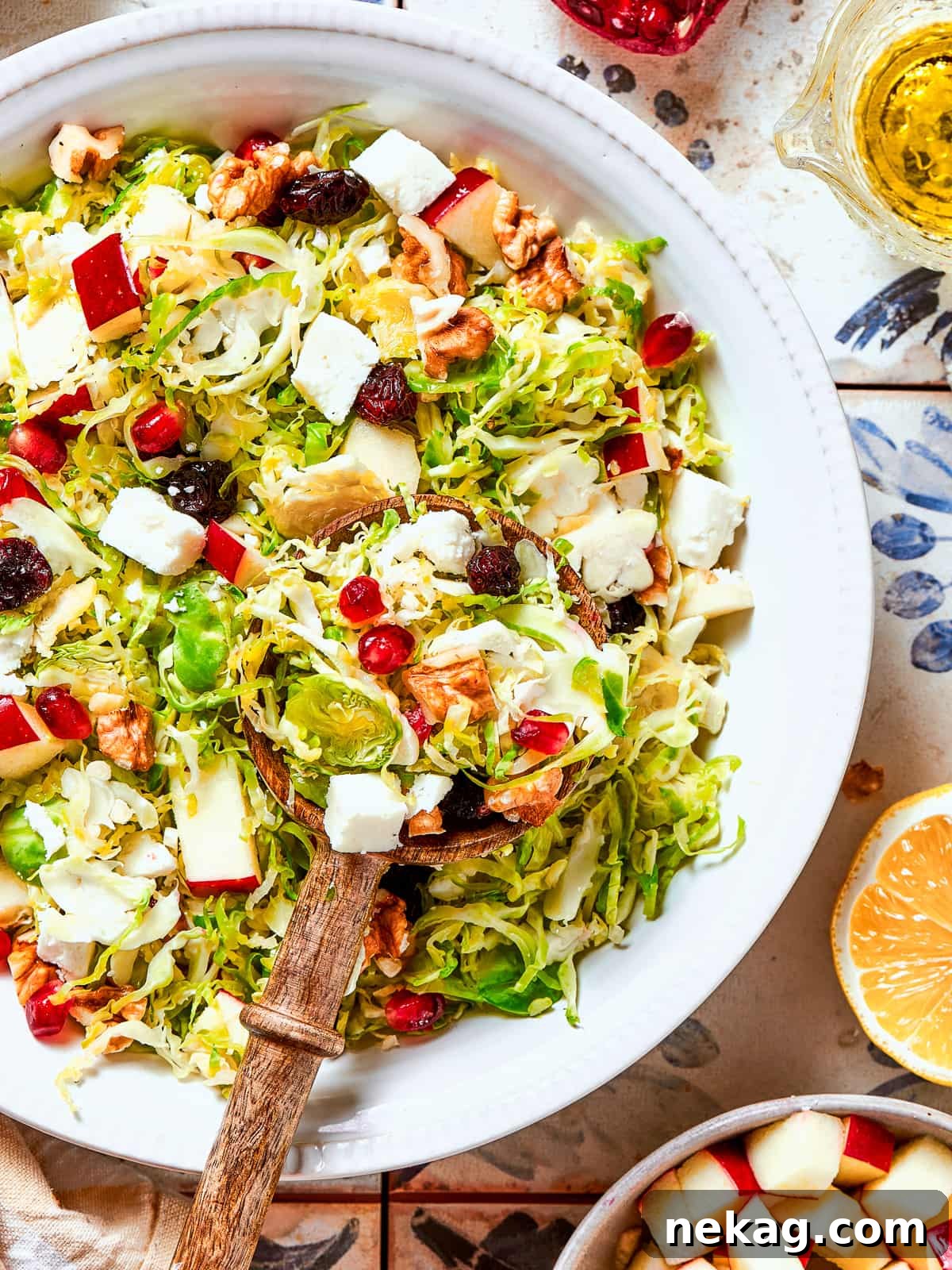 Elegant wooden salad tongs resting casually in a large bowl of freshly prepared shaved Brussels sprouts salad, inviting guests to serve themselves.