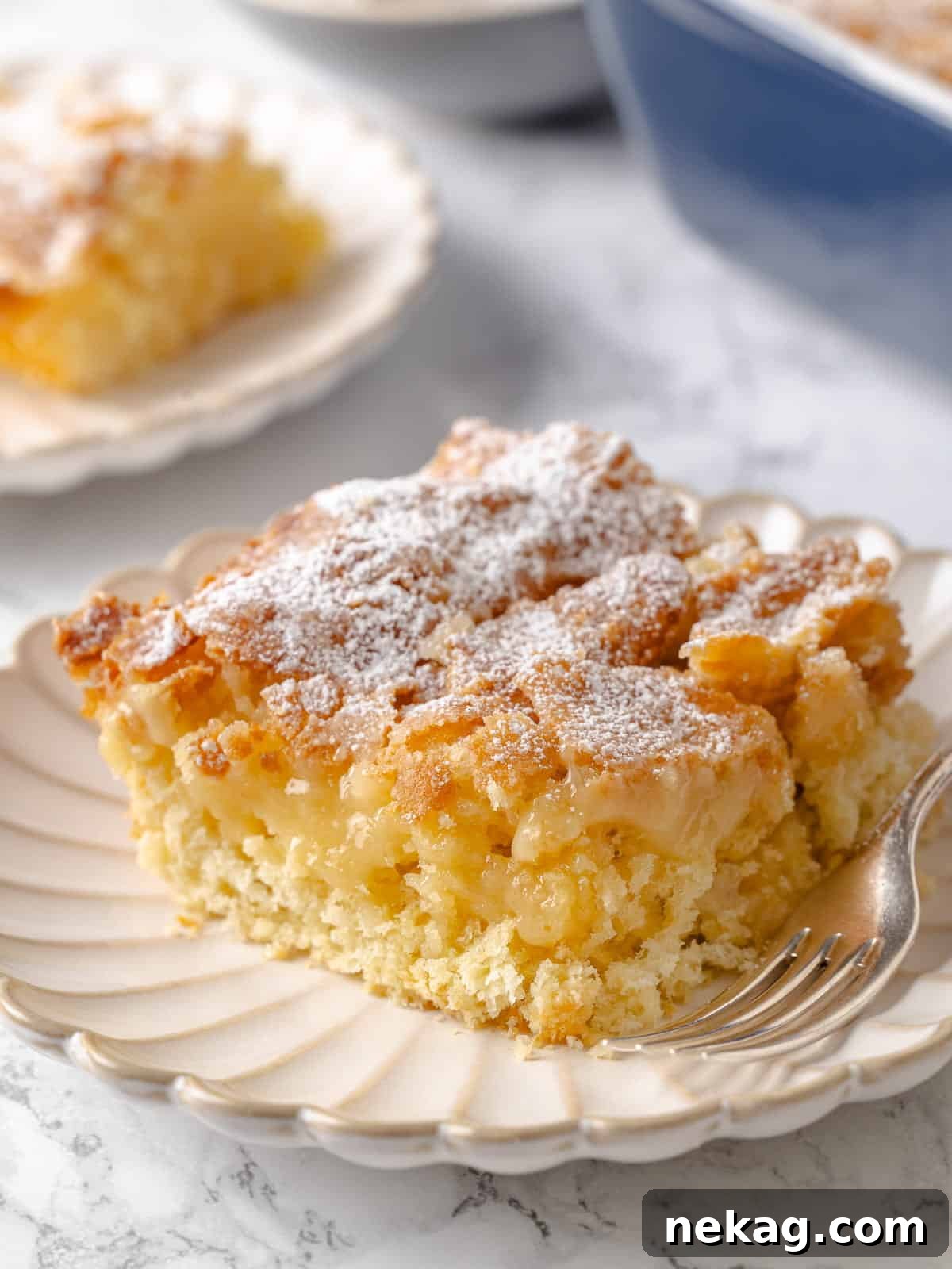 A visibly gooey middle sits beneath the crusty top of this traditional butter cake, inviting a taste.