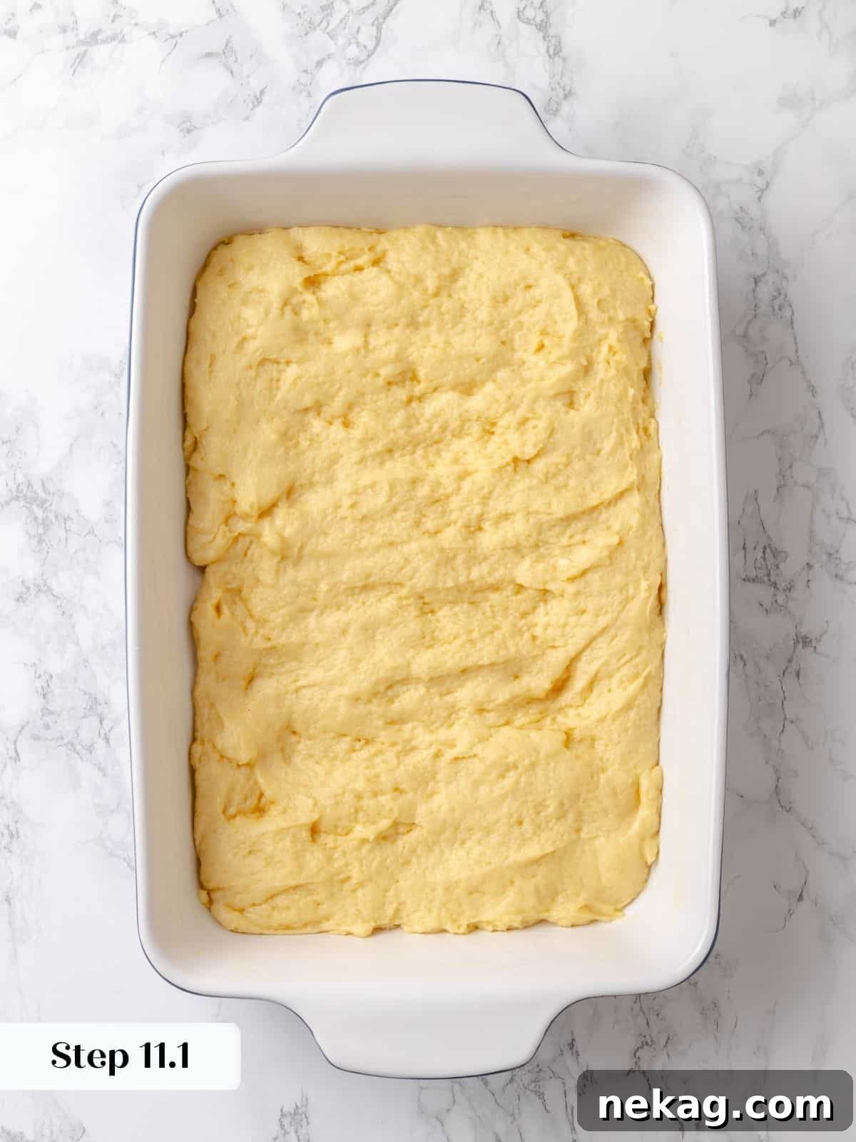 The dough has successfully risen in the pan, puffing up slightly and creating an inviting surface, now perfectly ready for the luscious sugar topping.