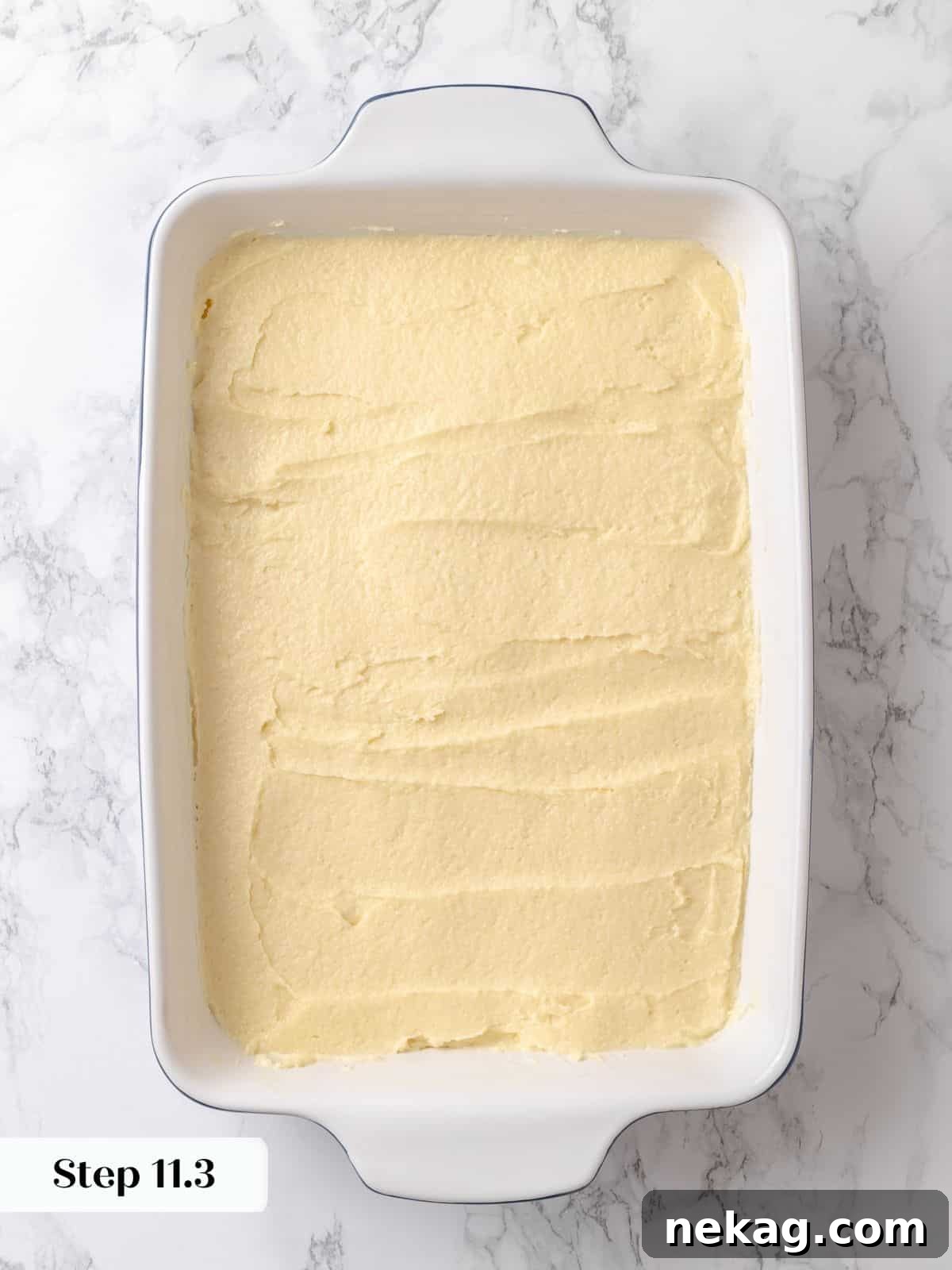 Soft batter spread to edges of the dish before rising and adding the topping, showcasing an even base.