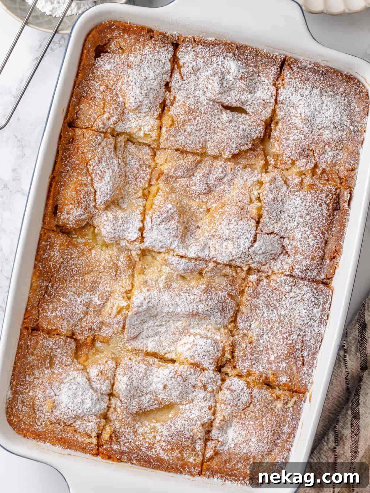 Gooey butter cake sliced into perfect squares, revealing its inviting gooey topping and tender, soft crumb.