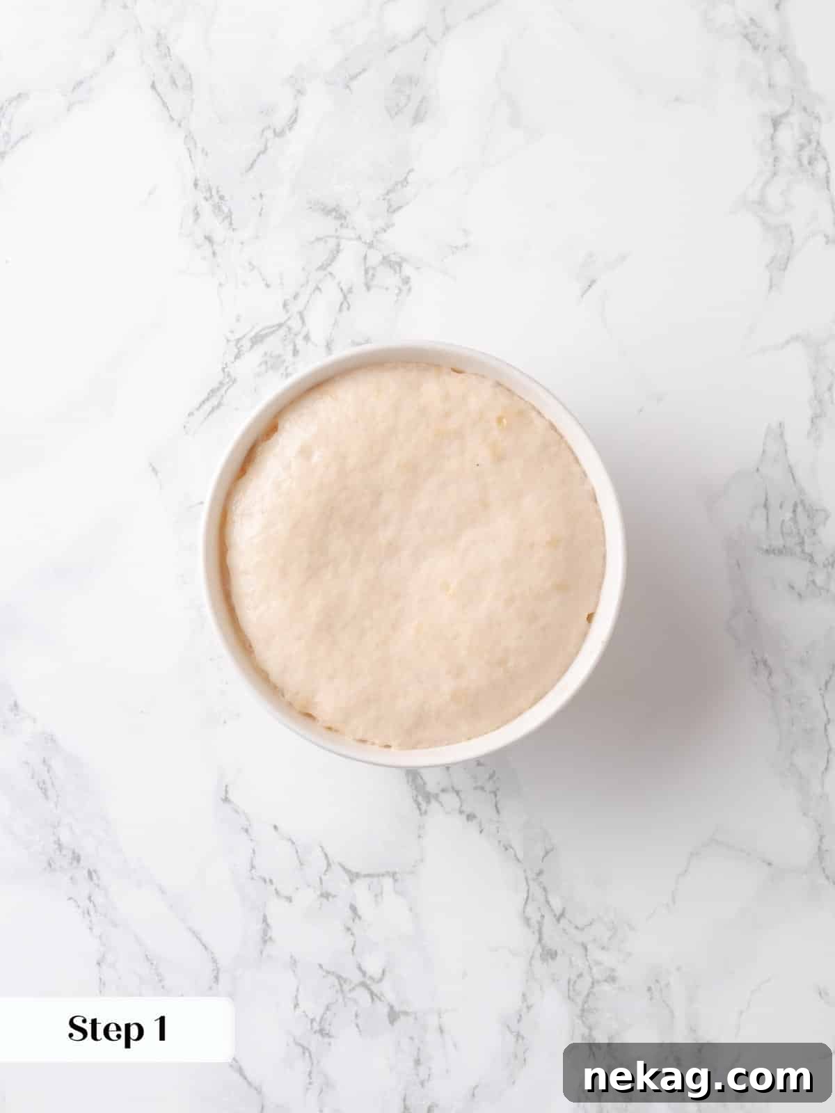 Yeast has foamed beautifully in warm water and milk, indicating it's active and ready for the cake batter.