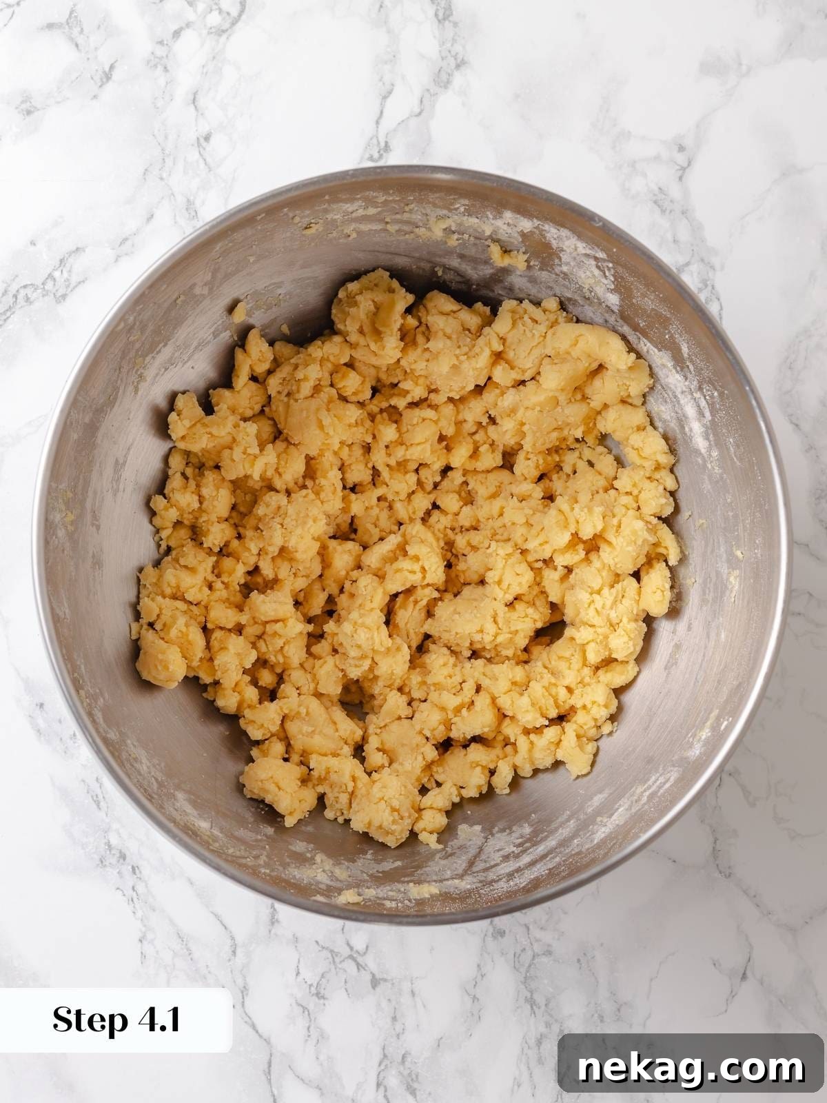 Mixing flour into the creamed ingredients and egg during the early stage of cake batter preparation, ensuring proper distribution.