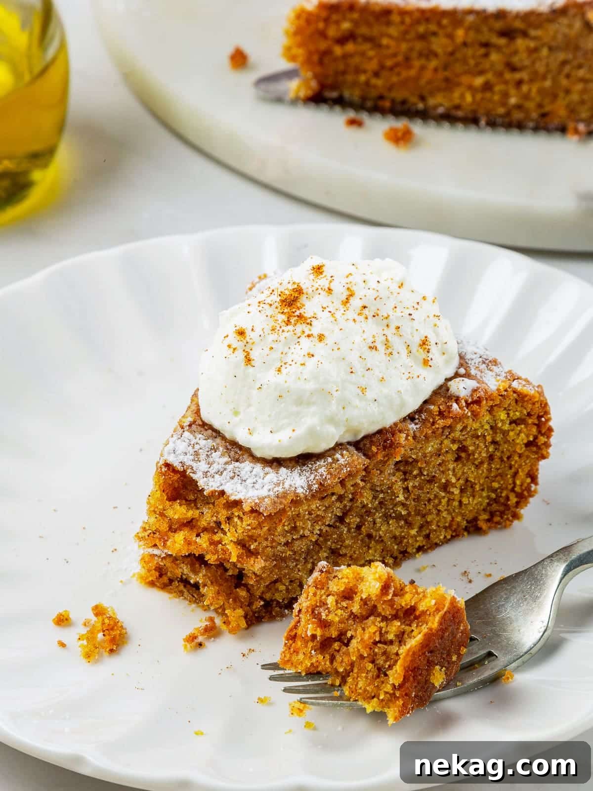 Mediterranean Pumpkin Delight 2 A delectable slice of pumpkin cake with a bite taken, revealing its incredibly soft, tender, and moist orange-hued interior, perfectly spiced for fall.