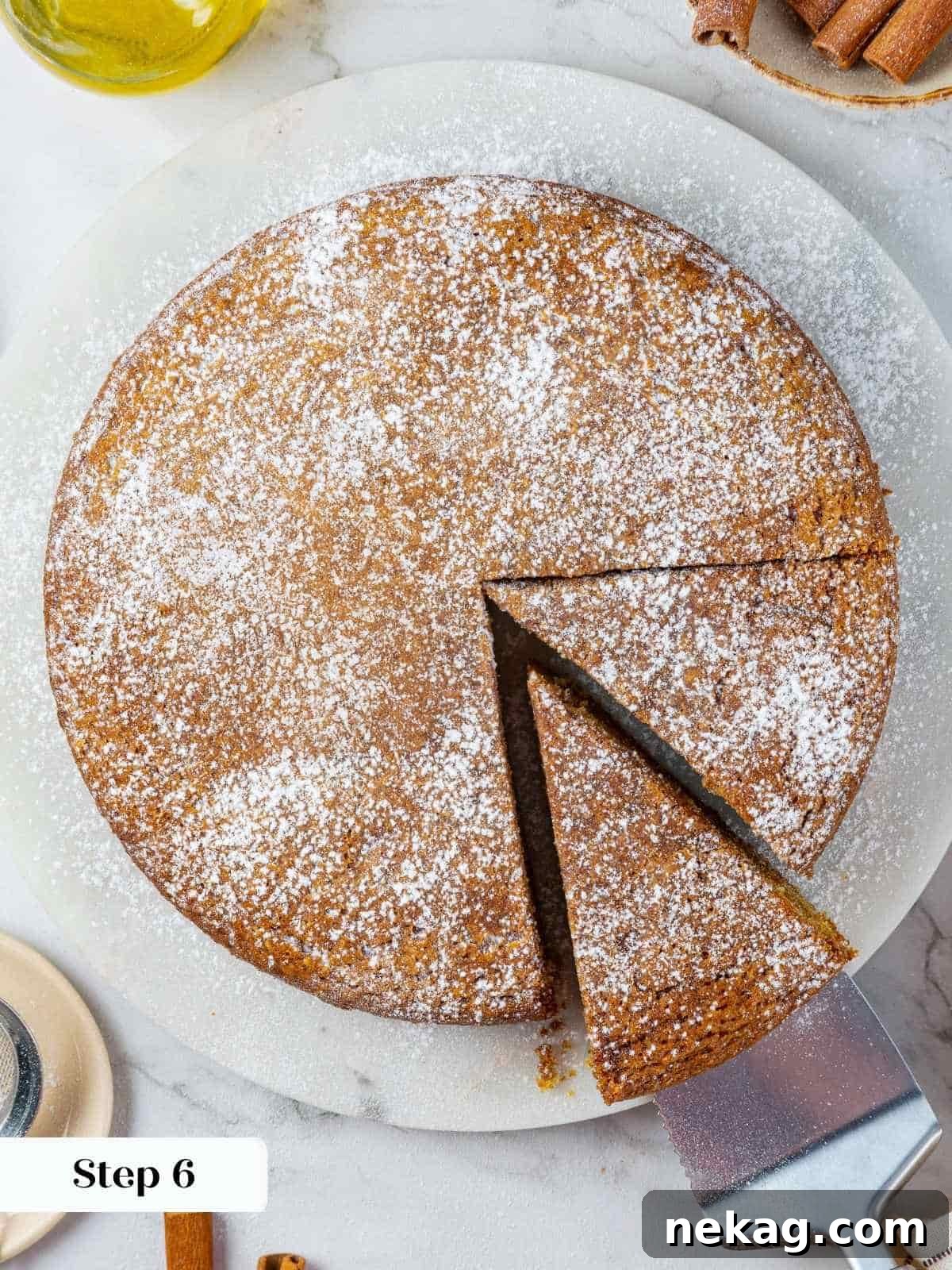 Mediterranean Pumpkin Delight 11 A delicate, fine layer of powdered sugar elegantly coats the surface of the cooled pumpkin cake after sifting, adding a perfect final visual touch and subtle sweetness.