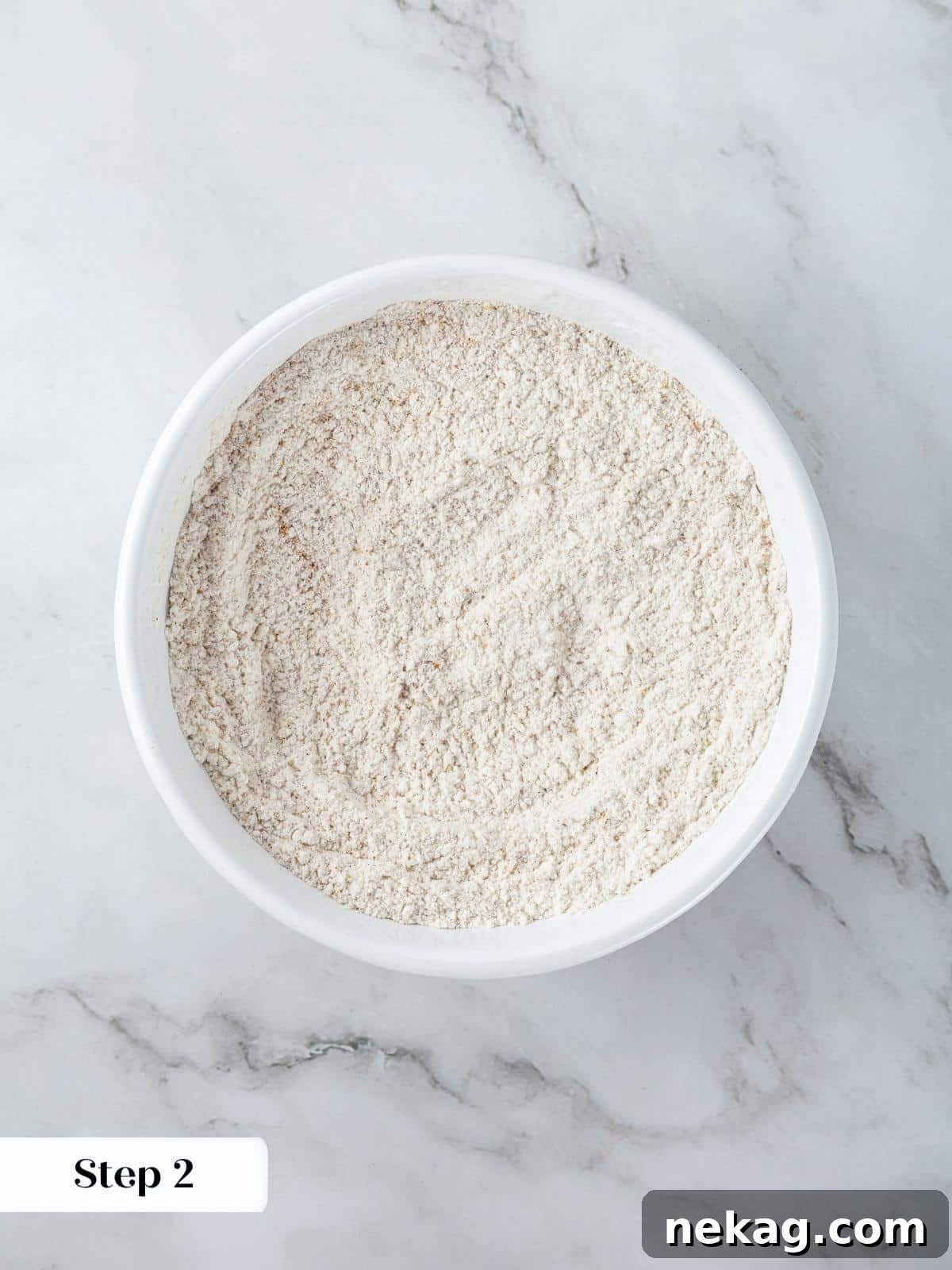 Mediterranean Pumpkin Delight 5 Pumpkin spice mix, flour, and salt are carefully combined in a medium bowl with a whisk, ensuring all dry ingredients are evenly distributed before folding into wet ingredients.
