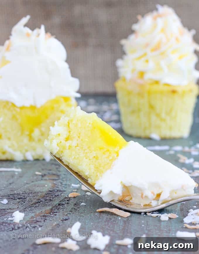 Lemon & Coconut Cloud Cupcakes 3 Close-up of a Lemon Coconut Cupcake showing the fluffy buttercream and golden toasted coconut sprinkles.