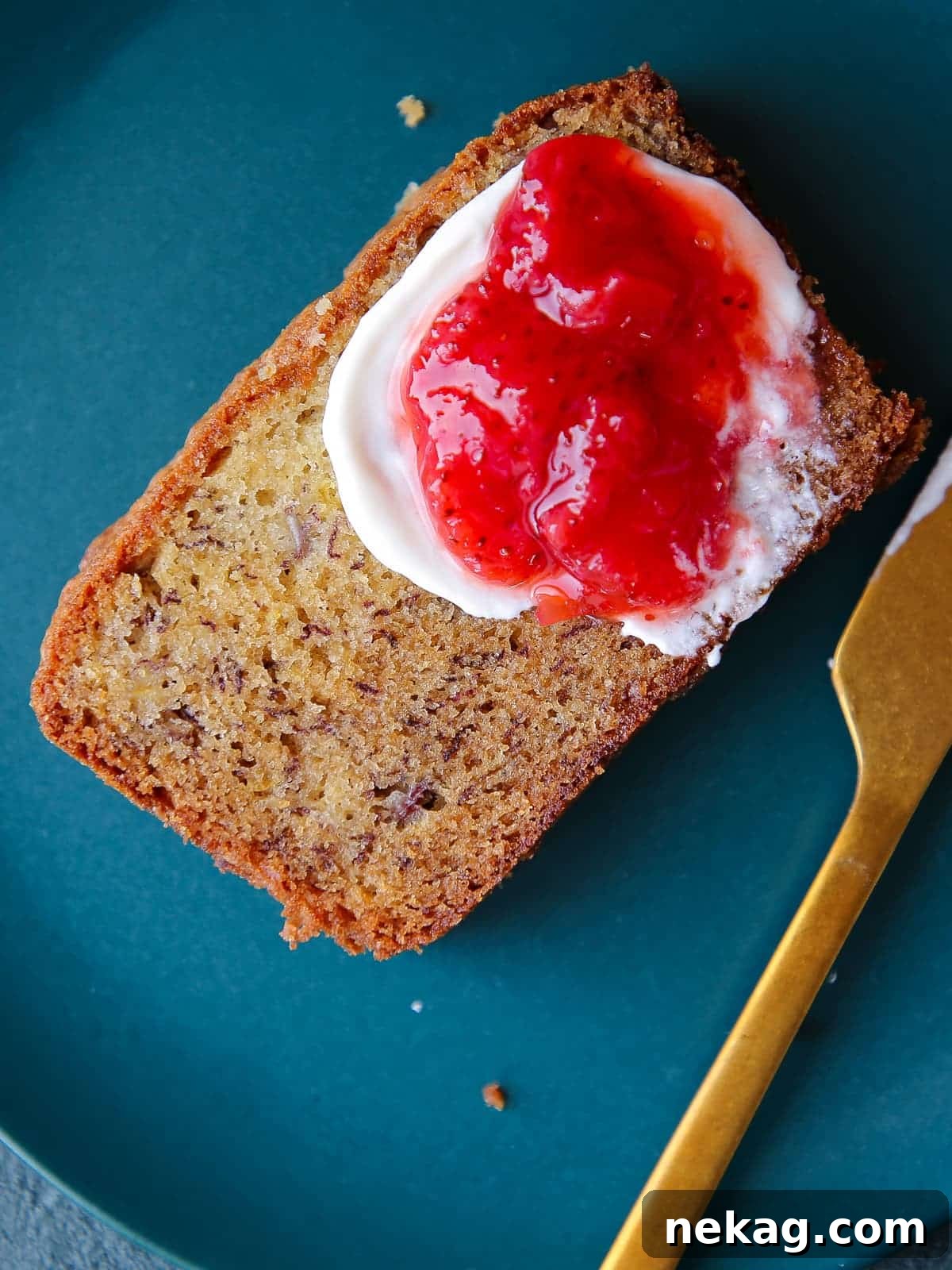 Thick slice of moist banana bread served on a vibrant blue ceramic plate, showing off its tender crumb.