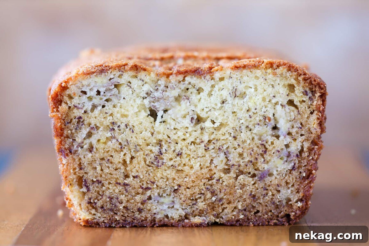 Inside texture of banana bread shown with visible soft crumb and golden outer crust, highlighting its moistness.
