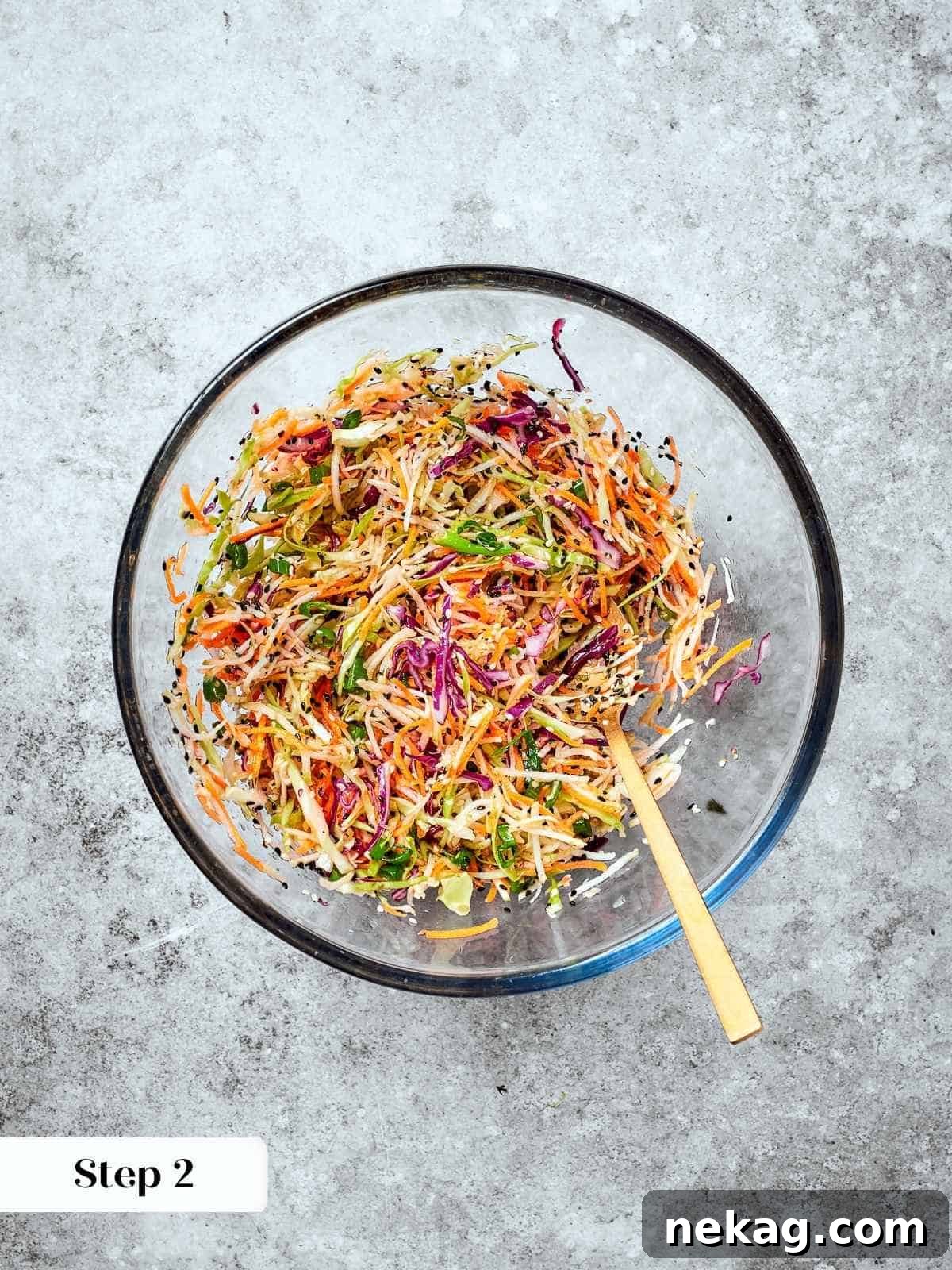 Fresh and Zesty Healthy Broccoli Slaw 6 Broccoli slaw fully combined with dressing in a bowl, sesame seeds and carrots evenly coated.