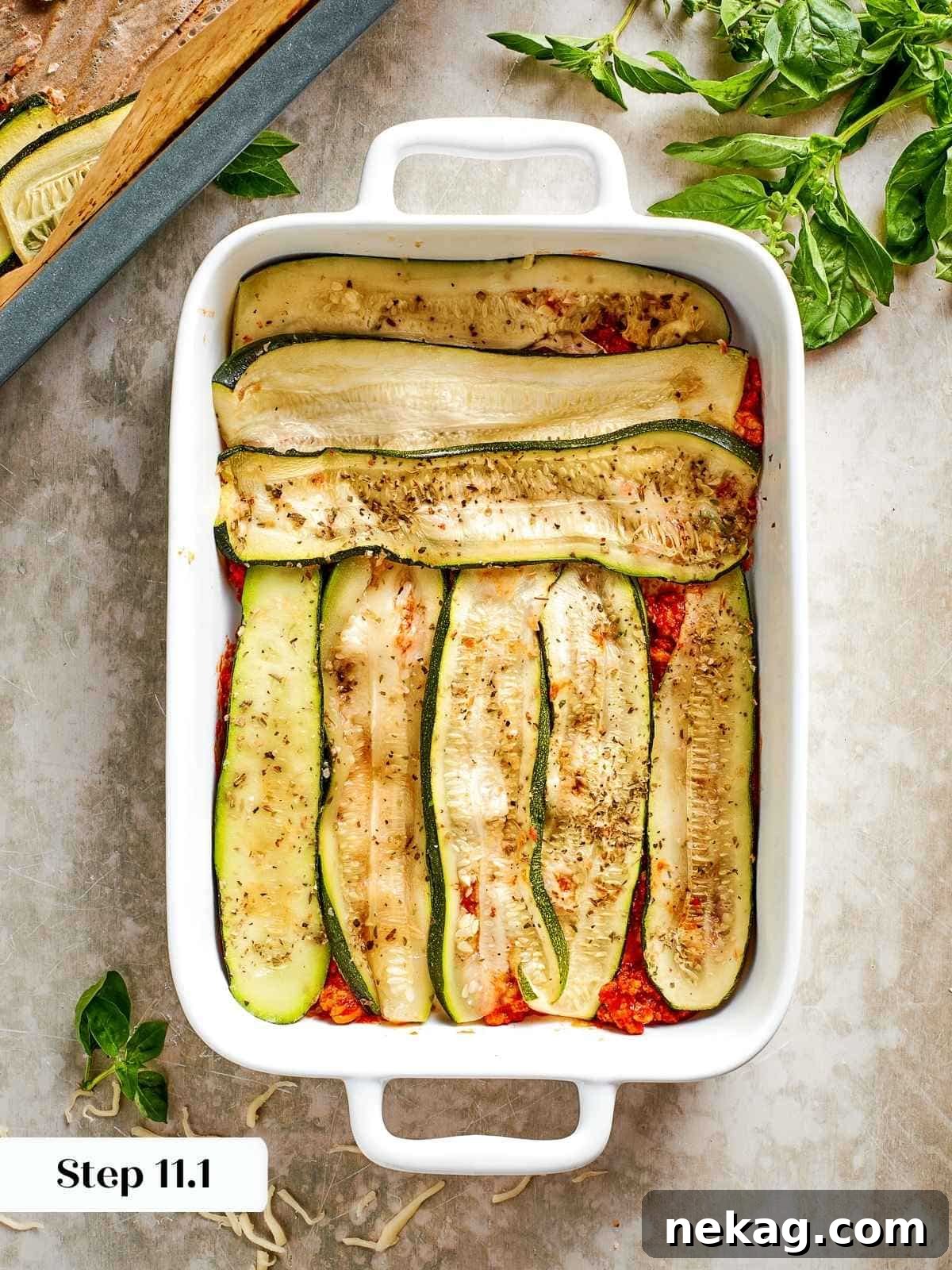 Thin, golden-roasted zucchini slices are carefully arranged to form the foundational layer of the lasagna, demonstrating the perfect pasta alternative.