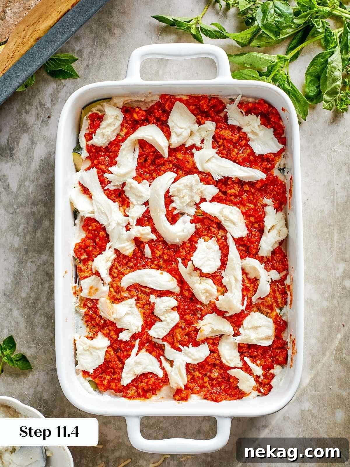 Delicate slices of fresh mozzarella are carefully placed onto a layer, ready to melt into gooey perfection as part of the lasagna's cheese strata.