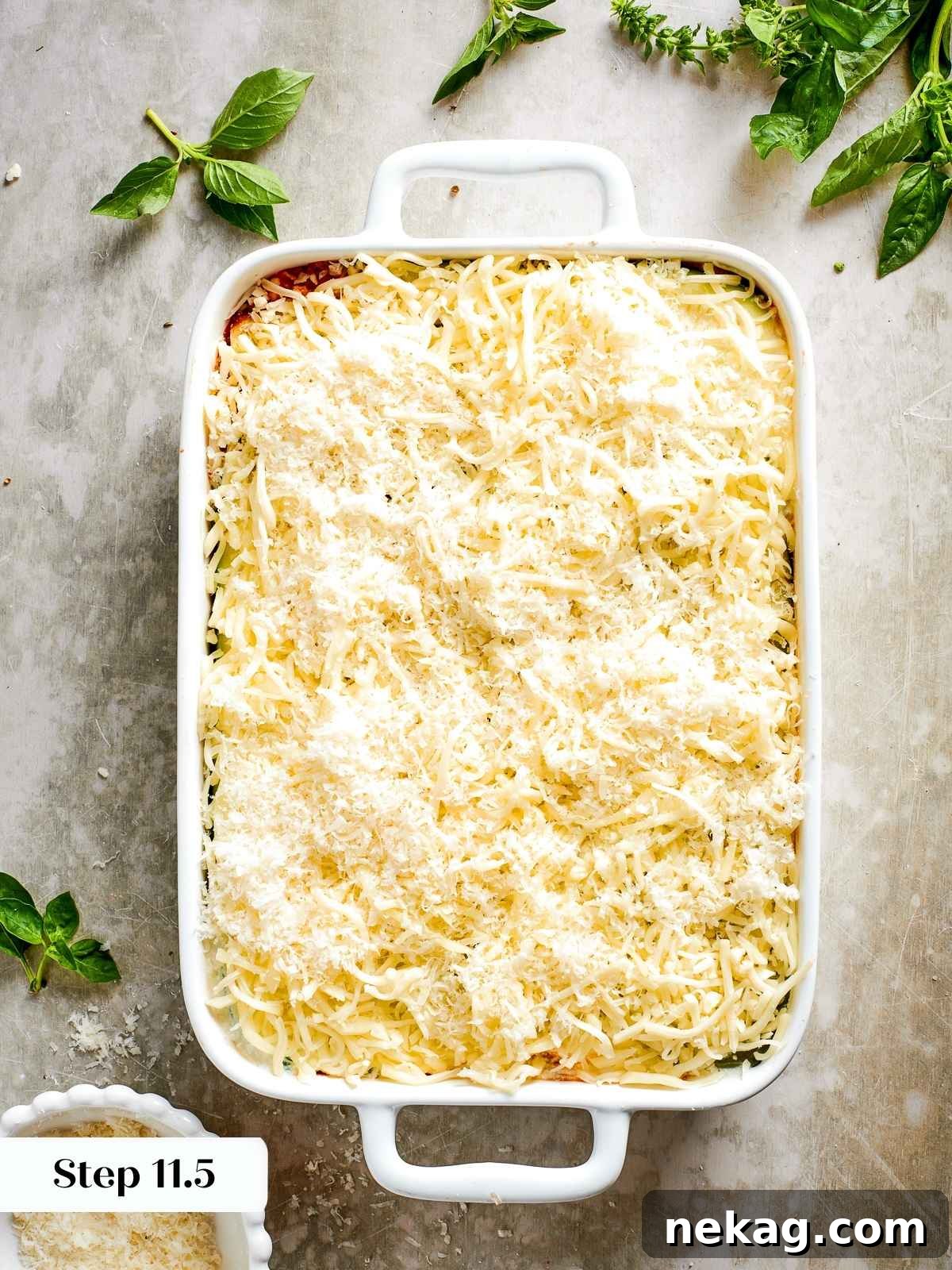 The final flourish: a generous sprinkle of shredded mozzarella and Parmesan cheese adorns the top layer of the assembled zucchini lasagna, promising a golden, bubbly crust.