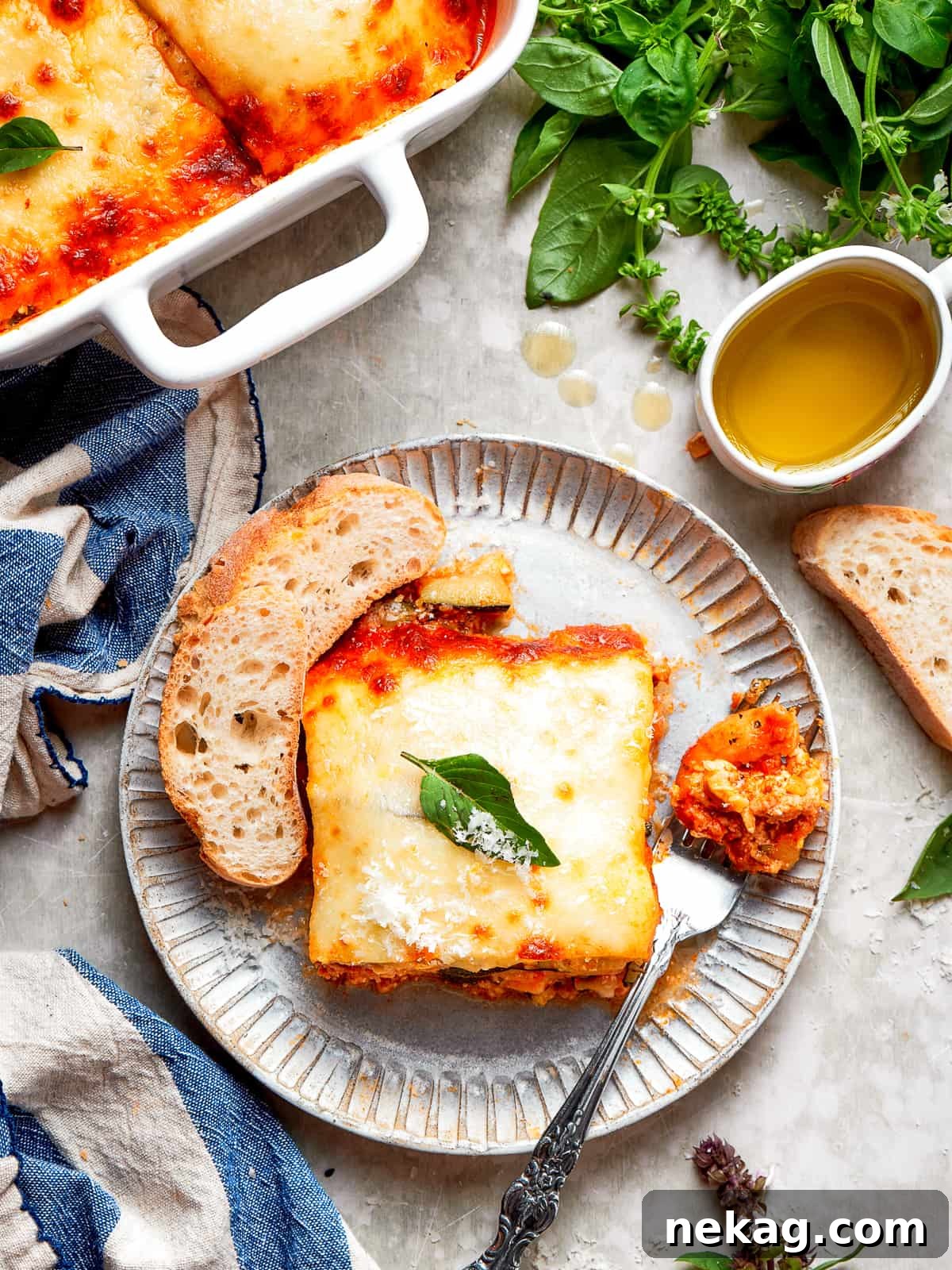 A glistening square of baked zucchini lasagna, fresh from the oven, crowned with bubbly, perfectly browned and melted cheese, ready to be served.