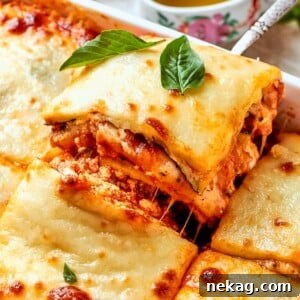 A perfect square of zucchini lasagna being lifted from the pan with clean lines and irresistibly melted cheese, ready to serve.