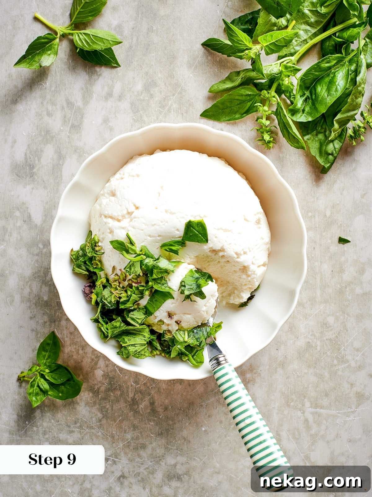 Creamy ricotta cheese is being gently mixed with fragrant fresh herbs in a small bowl, preparing it to become a luscious filling layer in the zucchini lasagna.
