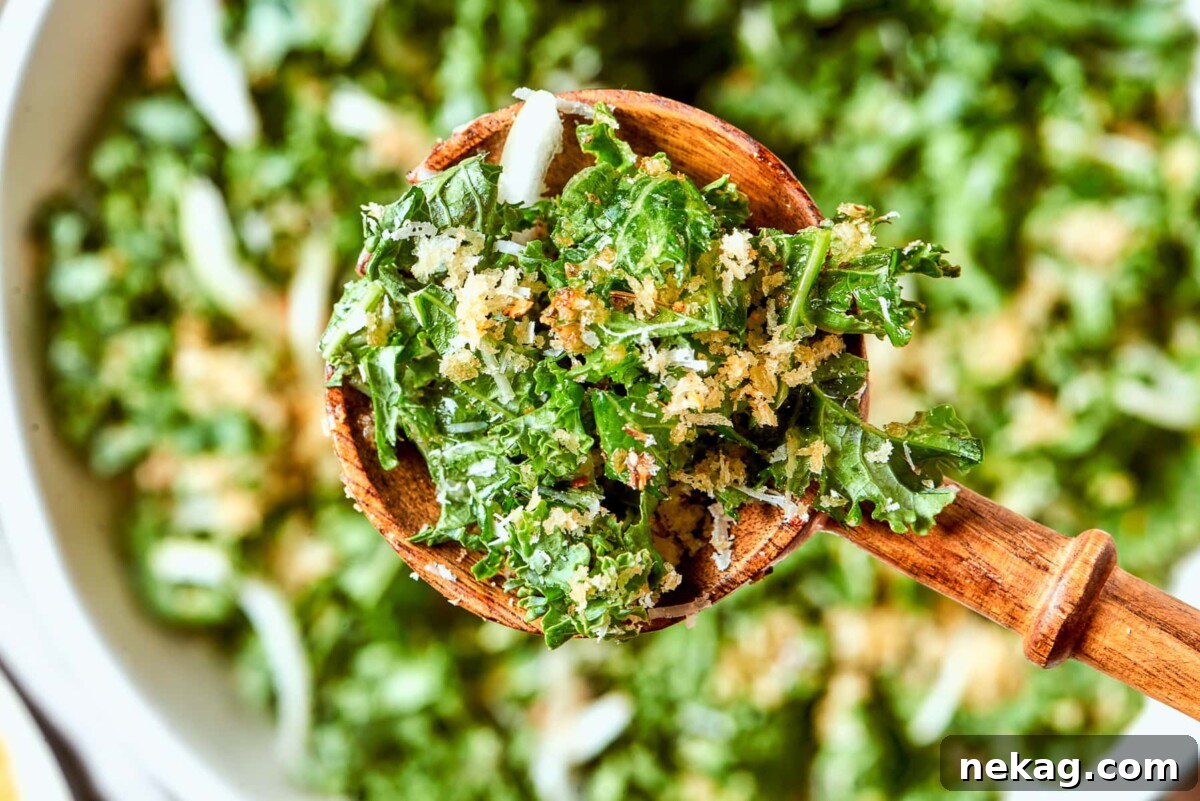 Sliced onion pieces visible throughout Tuscan kale salad with kale ribbons and breadcrumbs.