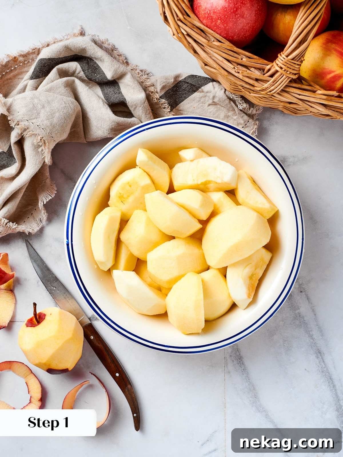 Fresh apples being peeled and quartered on a countertop, showing the initial preparation for homemade applesauce.