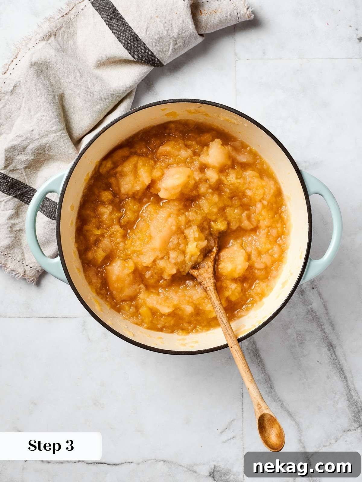 Apples cooking with water in a large pot, illustrating the initial cooking process for homemade applesauce.