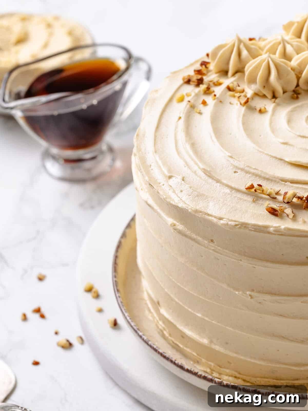 Velvet Maple Glaze 2 A bowl of creamy maple frosting next to a bottle of maple syrup, highlighting the key ingredient.