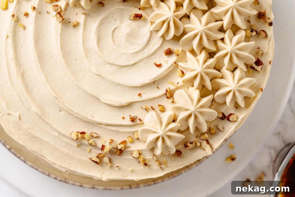 Velvet Maple Glaze 4 Maple frosting spread generously over a cake, decorated with a sprinkle of chopped nuts for added texture.