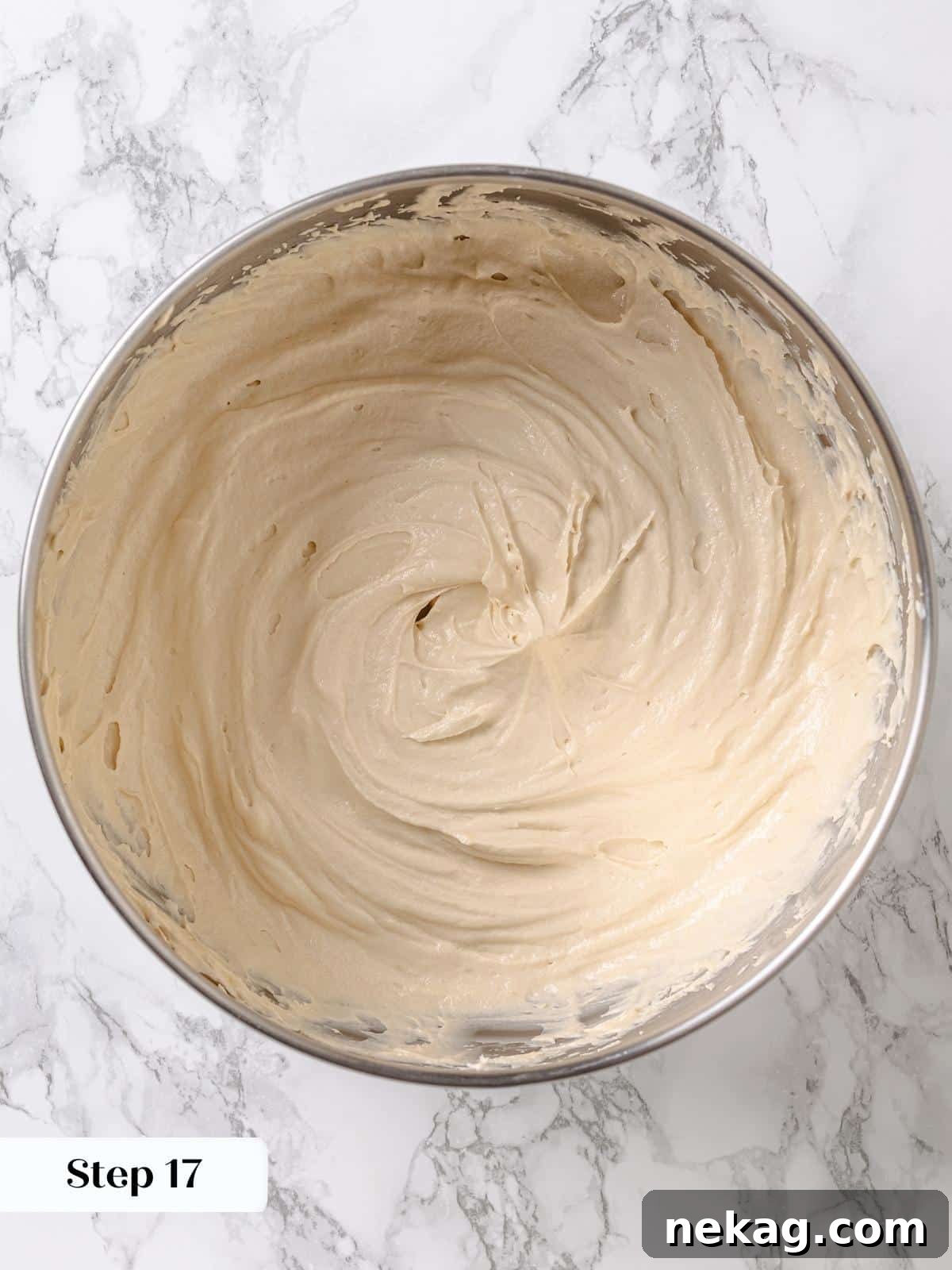 Golden Maple Delight 17 Finished maple frosting in a mixing bowl, showcasing its light and airy texture, ready for spreading over cake layers.