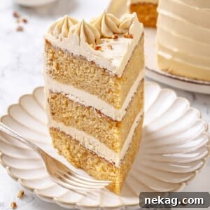 Slice of maple cake on a white plate with layers visible.