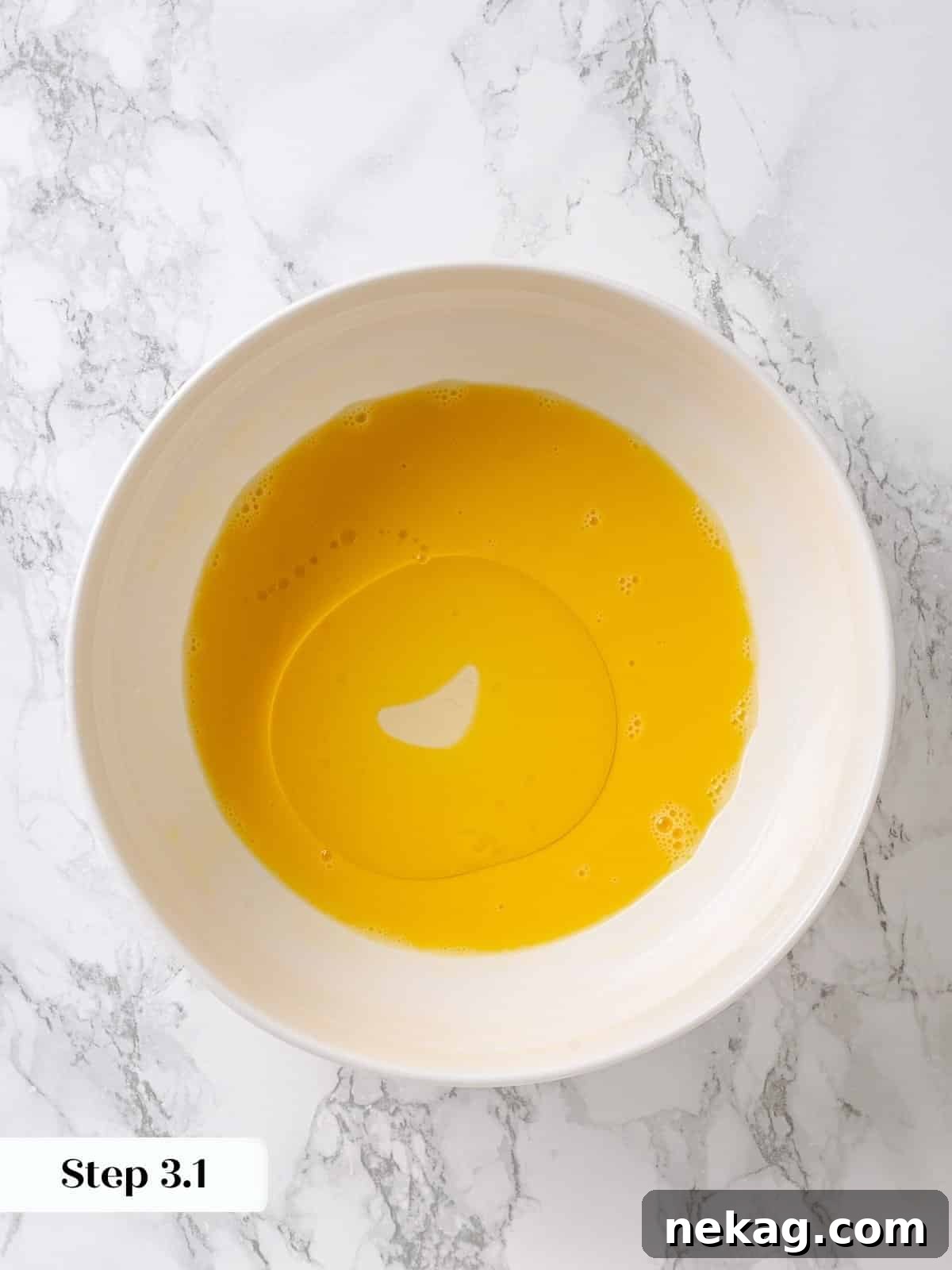 Golden Maple Delight 6 Oil being poured slowly into whisked eggs to create an emulsion for the cake batter.