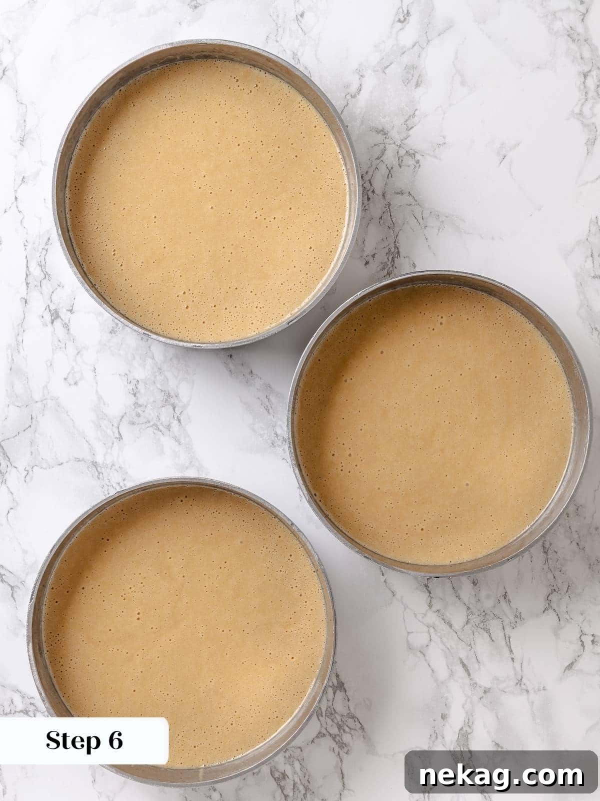 Golden Maple Delight 10 Maple cake batter poured evenly into round baking pans, perfectly portioned and ready for the oven.