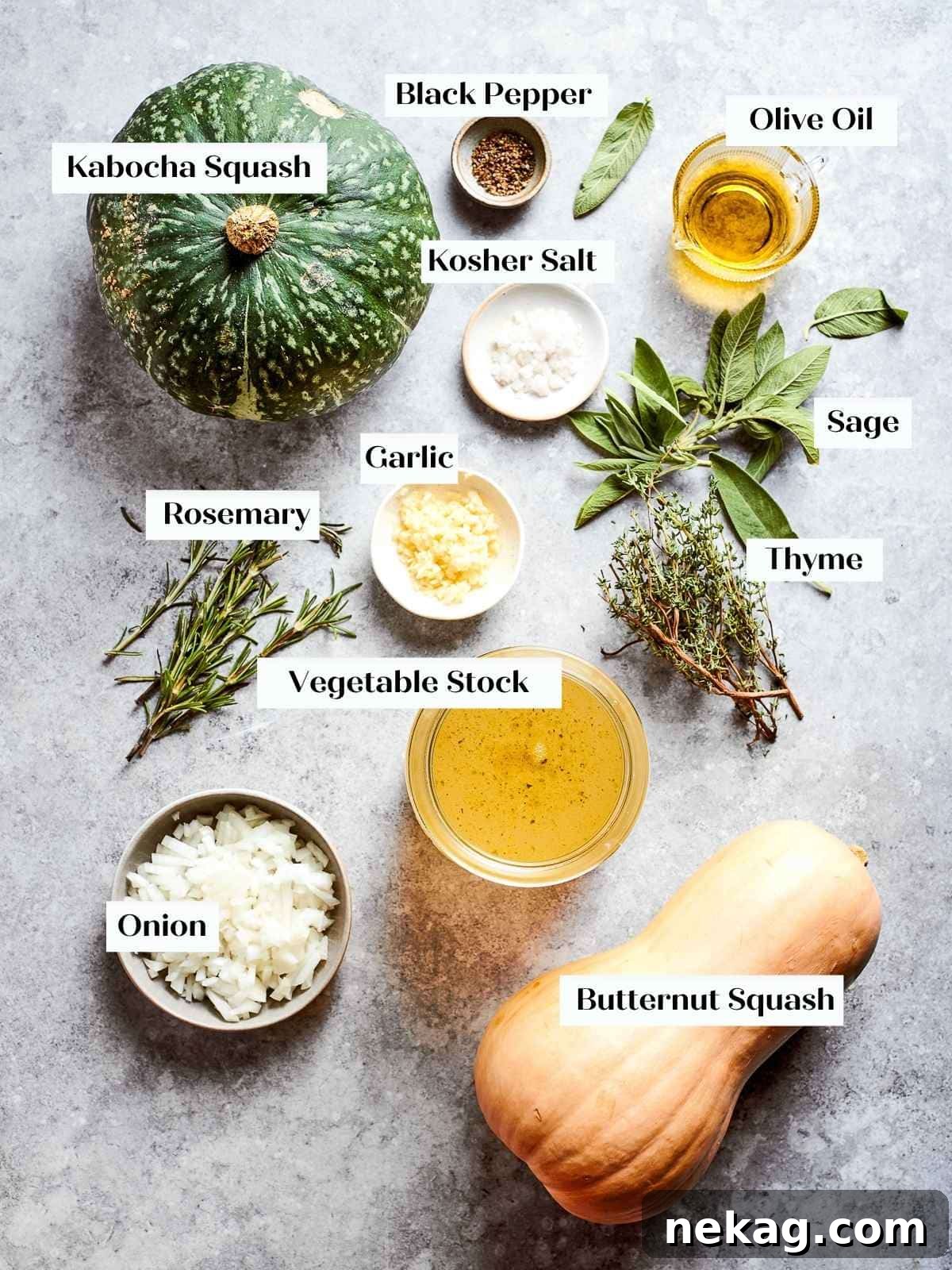 A vibrant display of fresh ingredients for squash soup, including raw butternut and kabocha squash, yellow onion, whole garlic cloves, and sprigs of fresh sage, thyme, and rosemary, alongside a bottle of olive oil, all neatly arranged on a countertop before cooking.