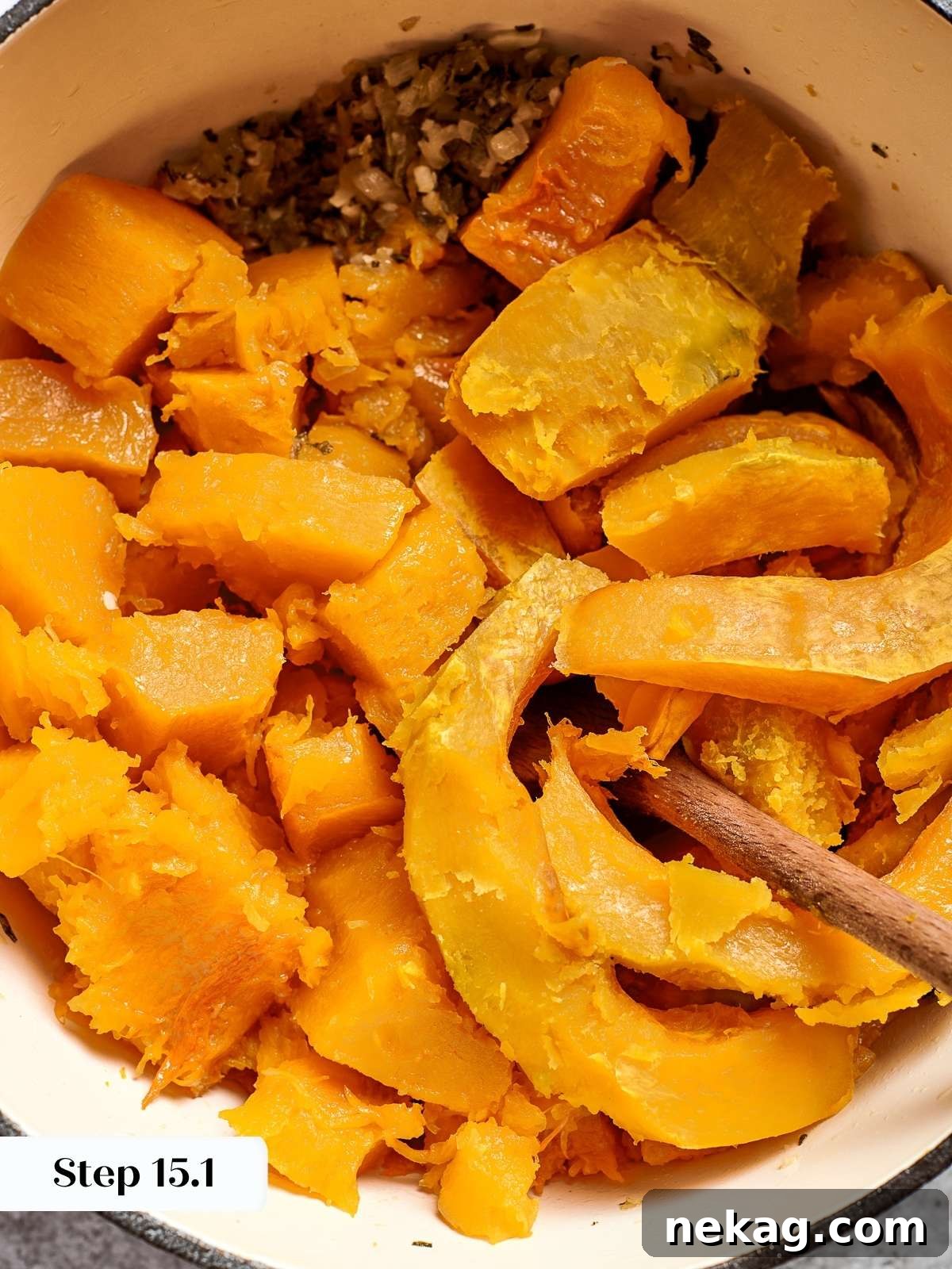 Cubes of roasted squash gently simmering in a flavorful broth, beginning to soften and break down, creating the rich base for a creamy soup.