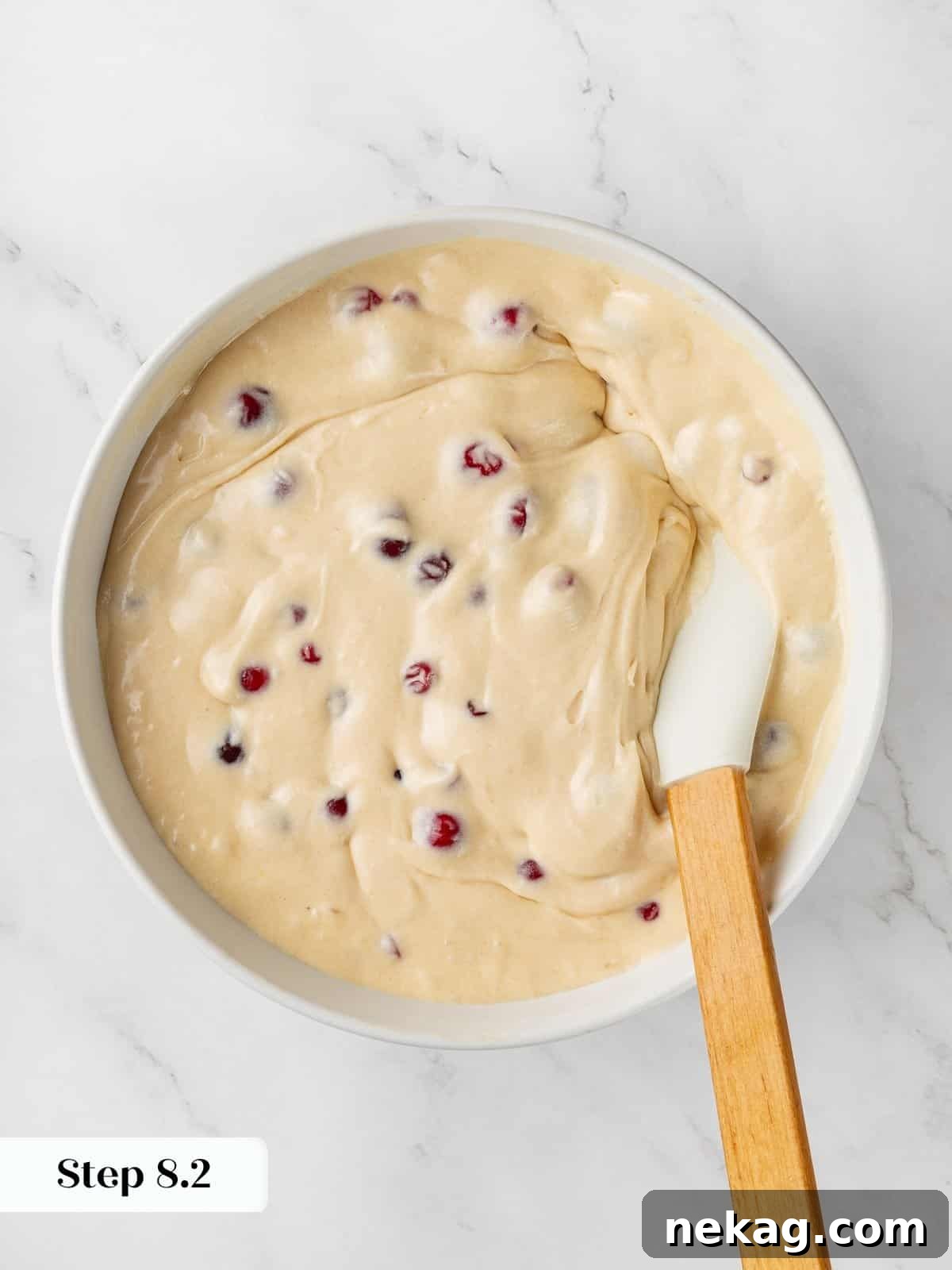 Jeweled Cranberry Cake 7 Thick, creamy cranberry cake batter resting in a bowl, showcasing its smooth texture before baking.