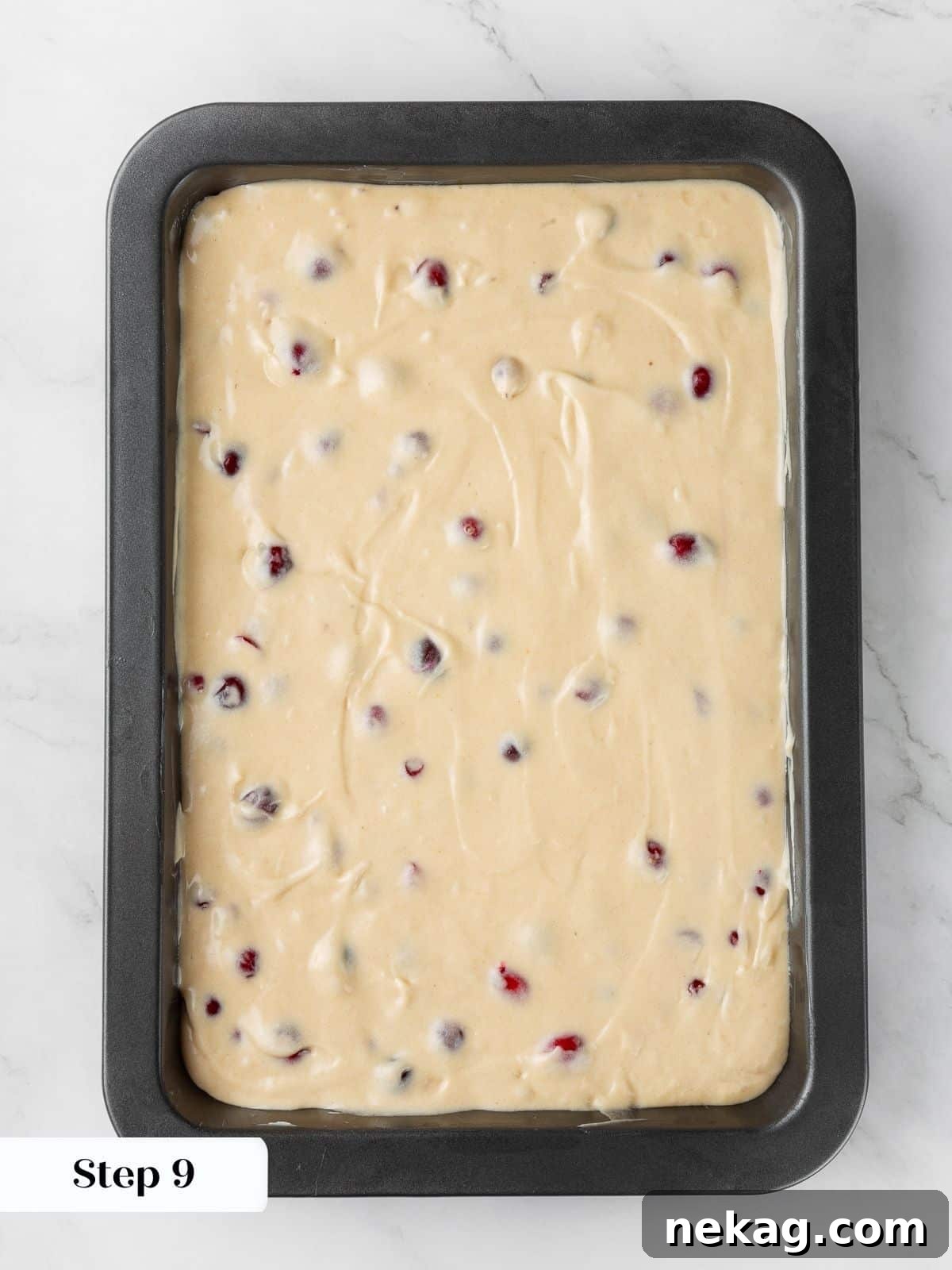 Jeweled Cranberry Cake 8 Smooth cranberry cake batter spread evenly in the baking pan, ready for the streusel topping.
