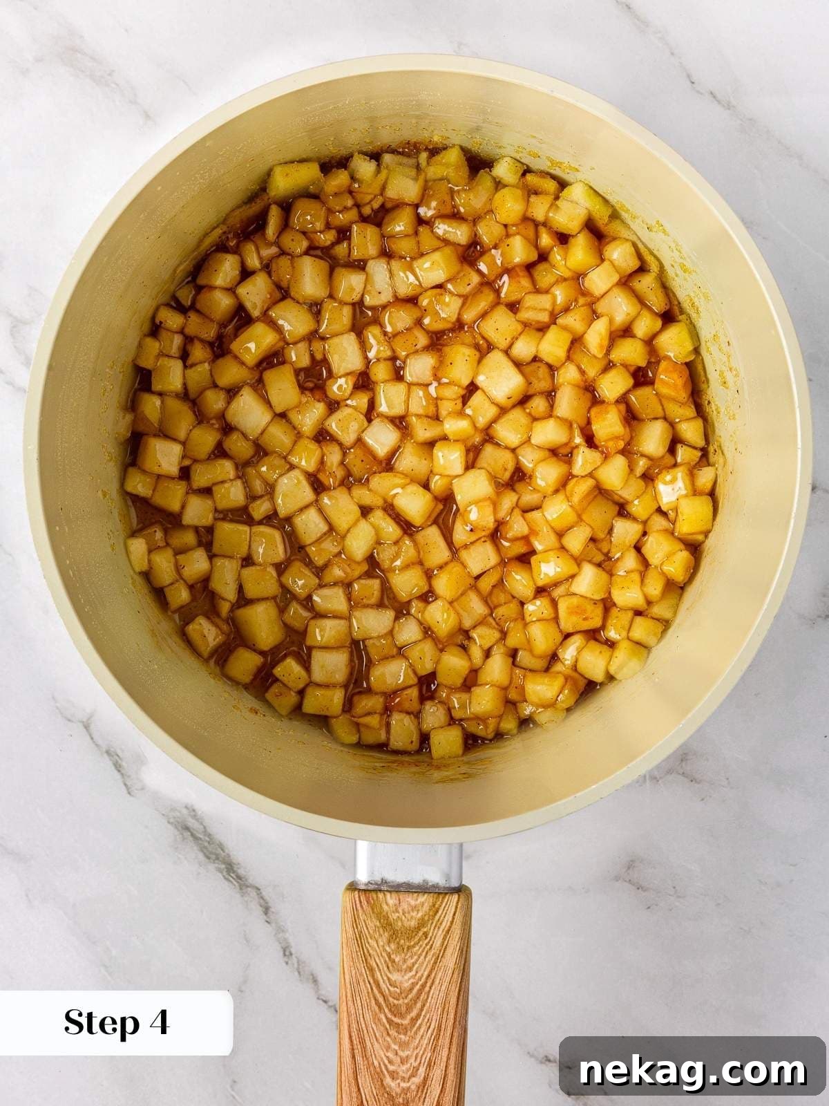 Apple Crumble Cookies 6 Diced apples bubbling in their own cinnamon-spiced sauce inside a saucepan.