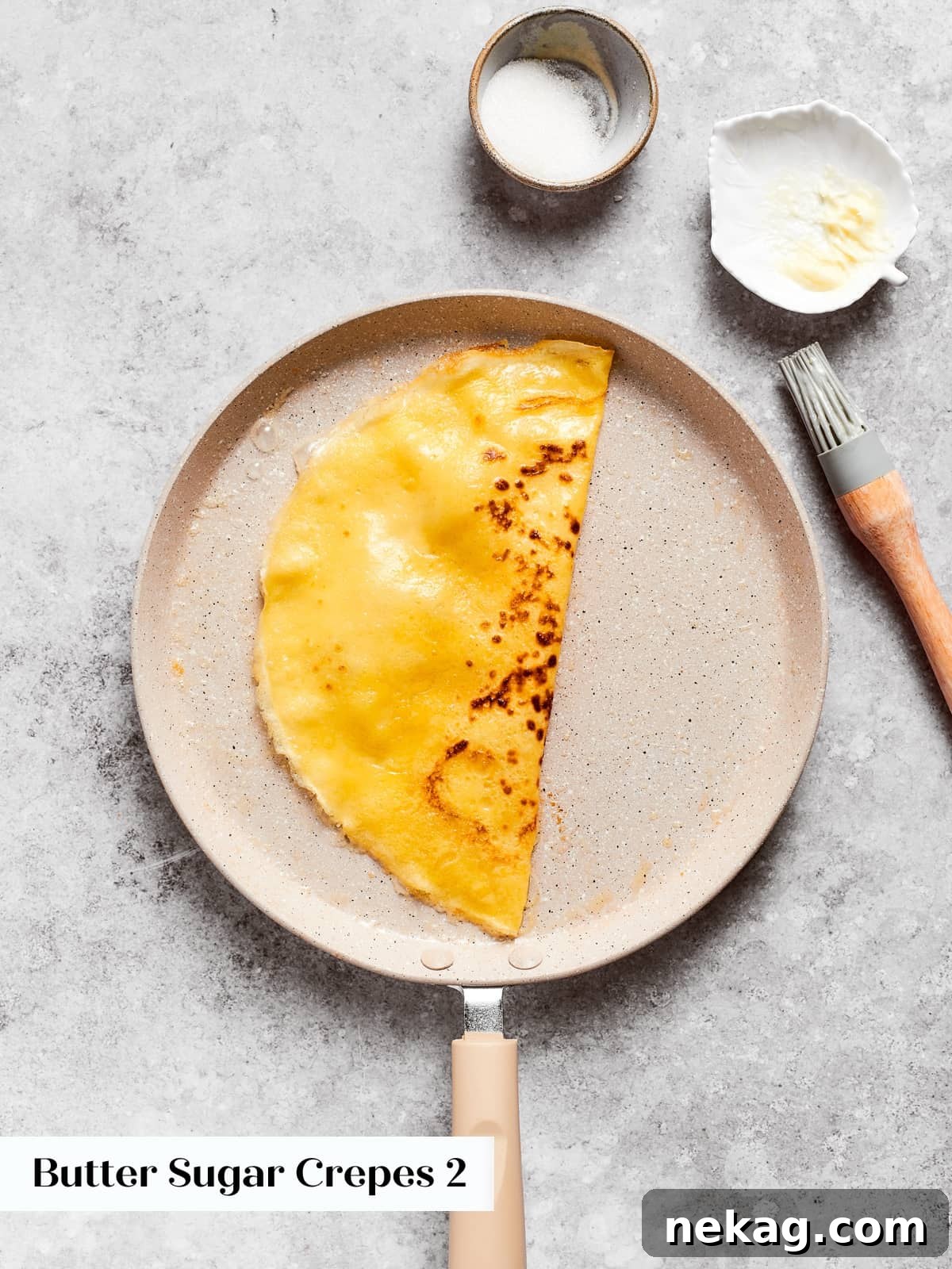 Soft crepe folded neatly in half, preparing for fillings like sugar or fruit.