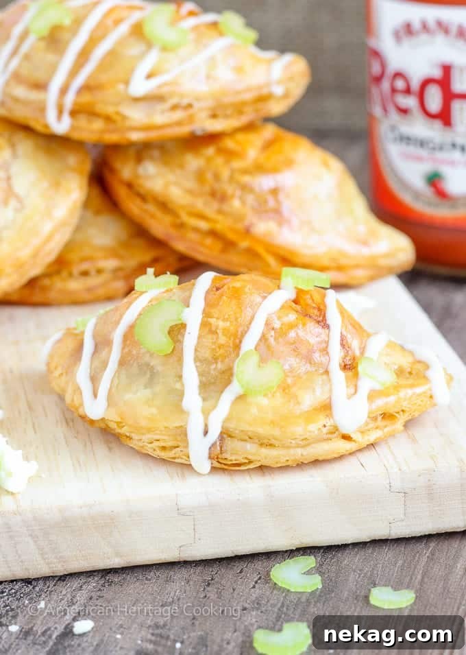 Spicy Buffalo Chicken Blue Cheese Hand Pies 2 Golden brown Buffalo Chicken Blue Cheese Hand Pies with flaky pastry, a perfect party appetizer.