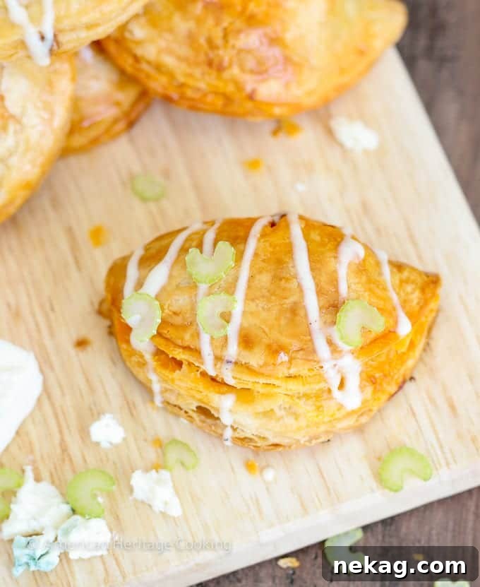 Spicy Buffalo Chicken Blue Cheese Hand Pies 3 Up close shot of golden brown Buffalo Chicken Blue Cheese Hand Pies, revealing their flaky texture.