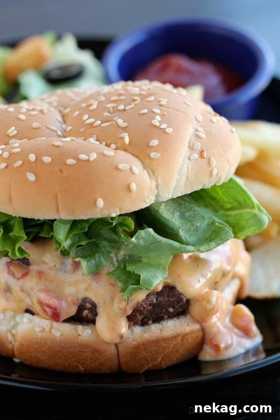Gooey Queso Burgers 4 Hand holding a delicious Queso Burger with melted cheese dripping, ready to eat