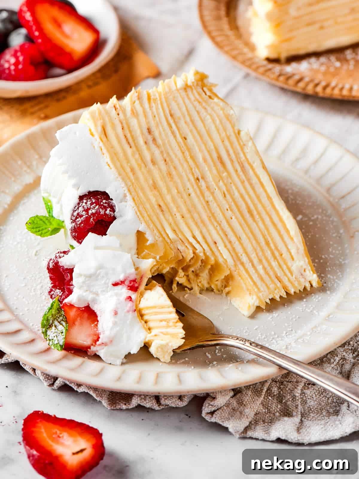 Delicate Layered Crepe Dessert 2 A small forkful of layered crepe cake lifted to show the tender texture and vanilla cream.
