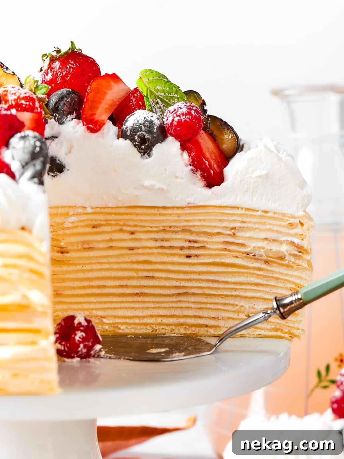 Delicate Layered Crepe Dessert 18 A cake server sliding under a slice of layered crepe cake filled with vanilla cream.